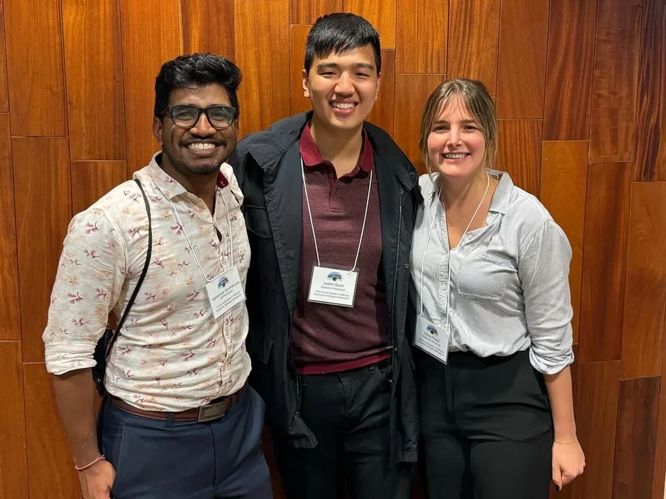 3 students taking a photo together while at a conference