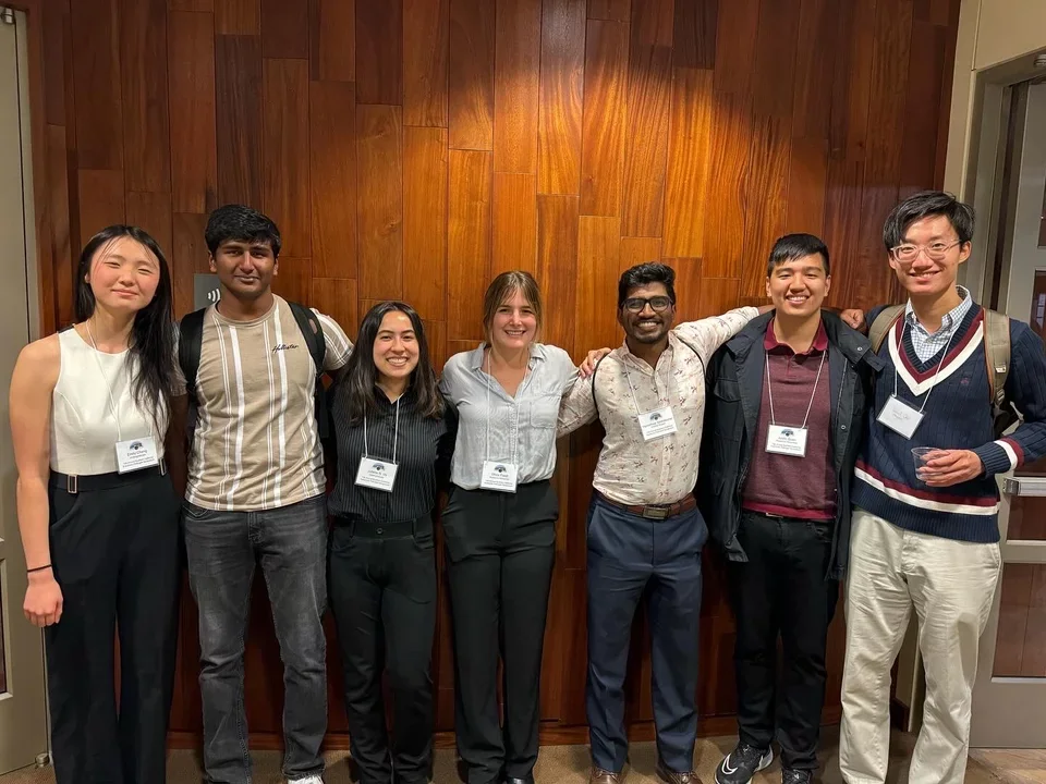 7 students taking a group photo at a local conference