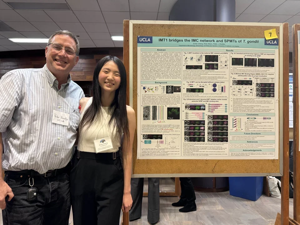 professor and student standing next to a poster smiling