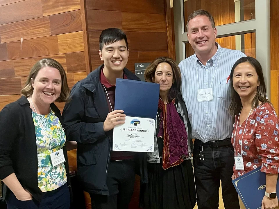 student celebrating his award of Best talk at a conference