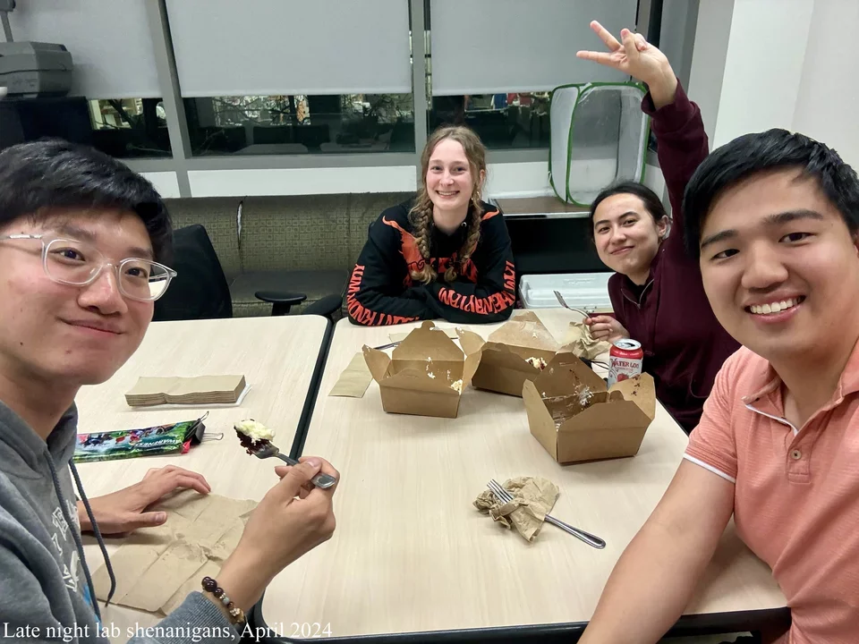 4 students around conference room table eating 