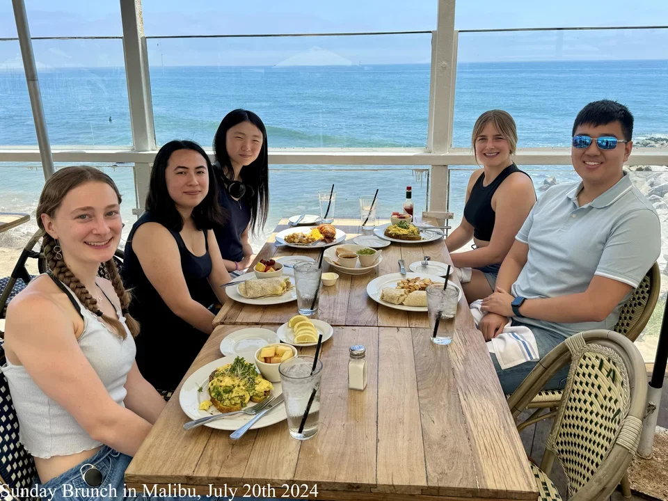 5 students eating brunch by the ocean