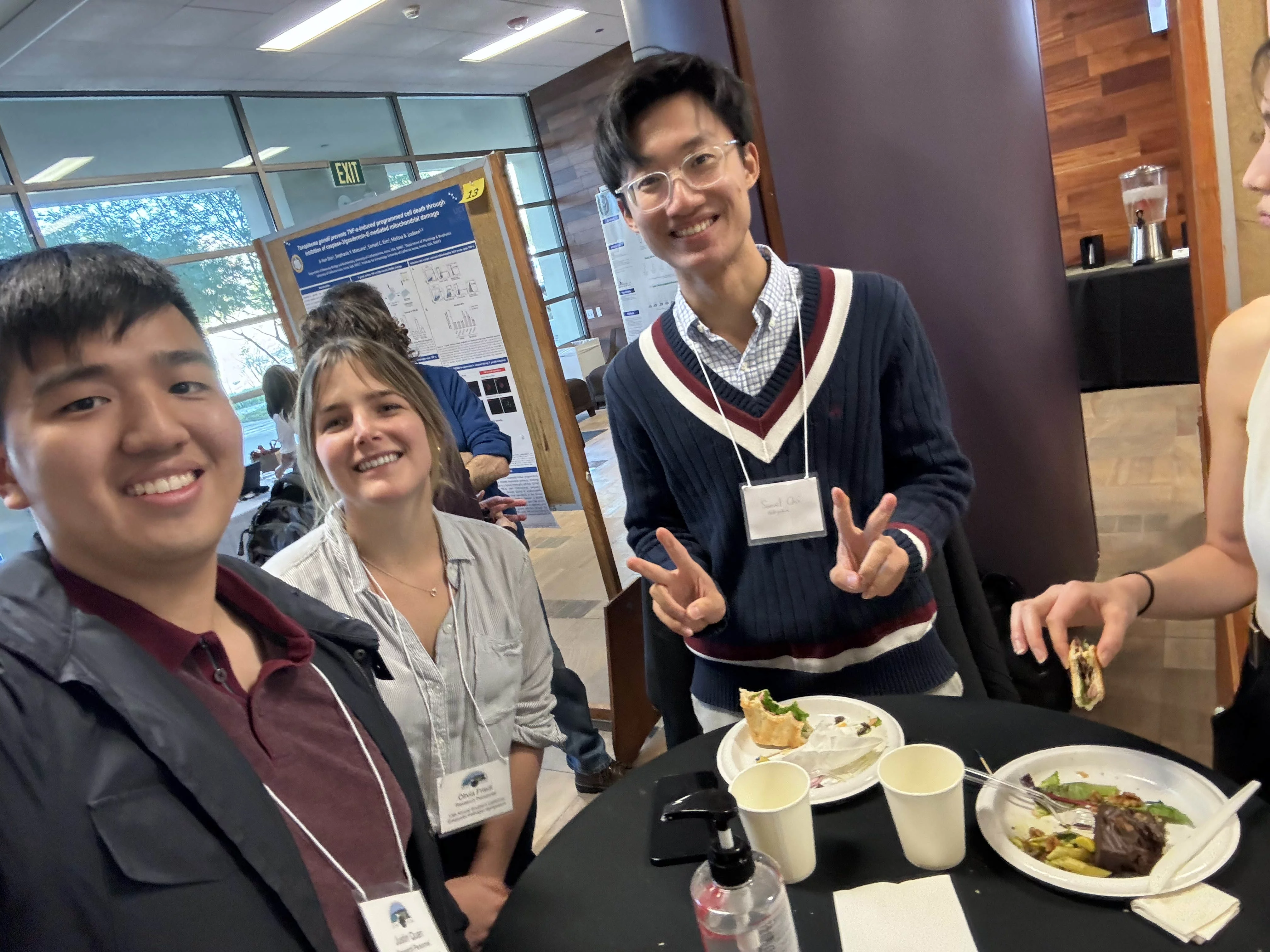 3 students taking a selfie at a conference while also snacking on food