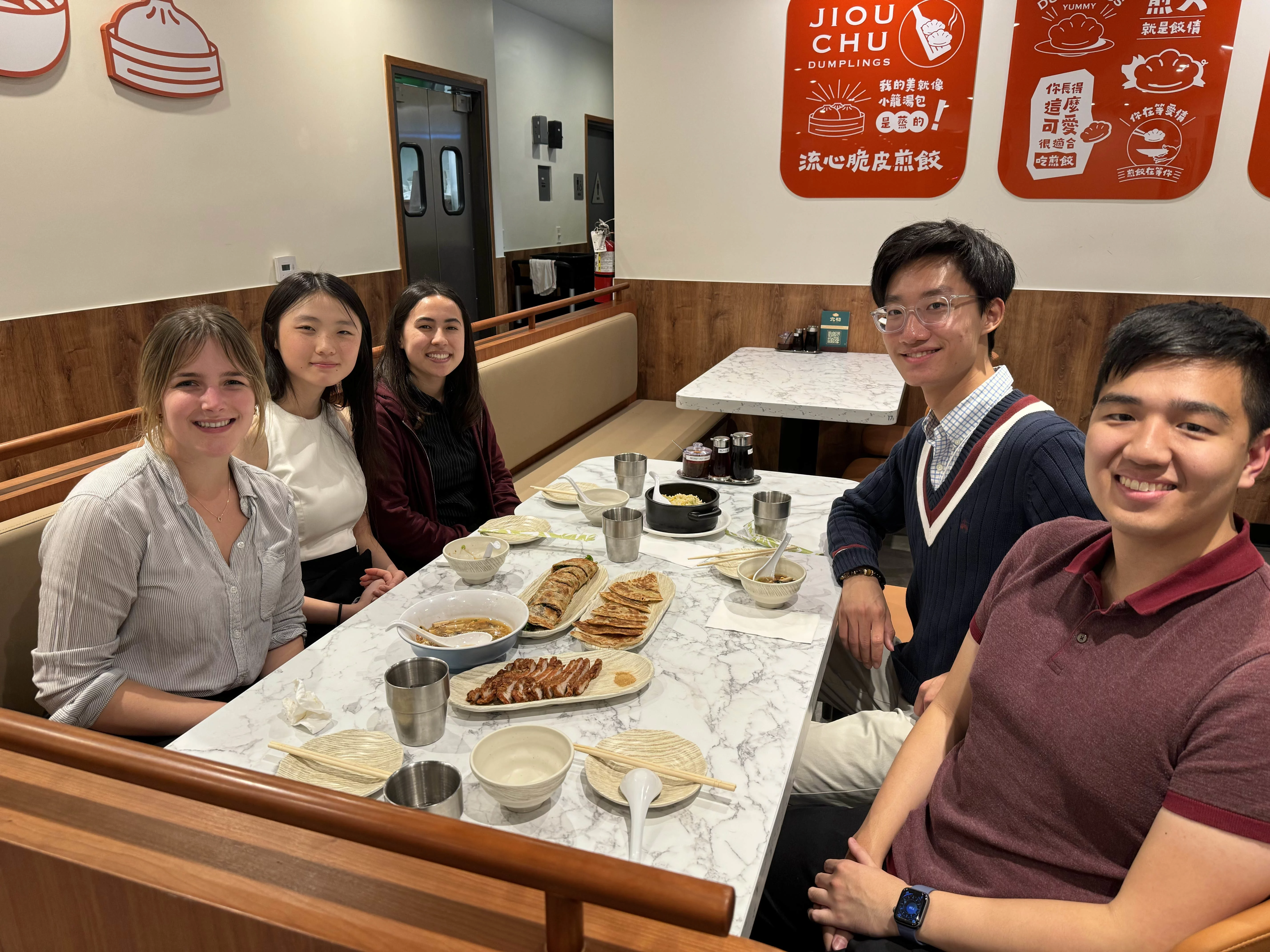 5 students eating dumplings at a restaurant