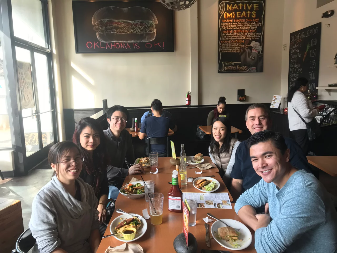 The entire lab are posing for a photo during a lunch social at a restaurant.