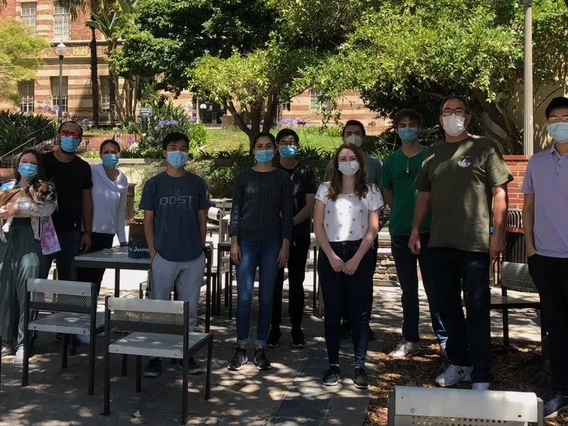Outdoor group photo taken during the pandemic. Lab members all wearing masks to be safe.